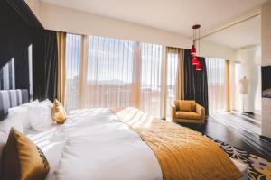 a large bed in a room with a large window at Kameha Grand Bonn in Bonn