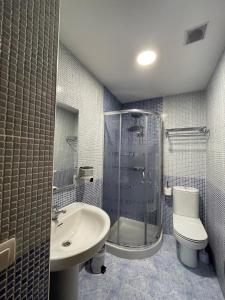 Un baño con ducha, lavabo e inodoro. en Hostal Santiago 2, en Burgos