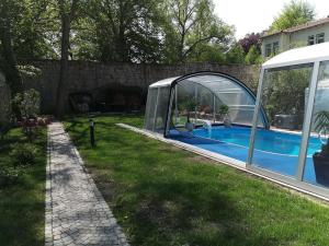 une serre et une piscine dans une cour dans l'établissement Apartment London, à Mühlhausen