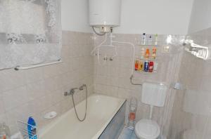 a bathroom with a bath tub and a toilet at Boltíves Vendégház in Sajógalgóc +32 photos