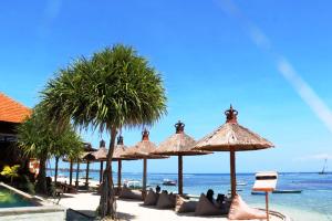 Pemedal Beach Resort في نوسا ليمبونغان: مجموعة من المظلات على شاطئ قريب من المحيط