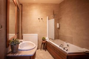 a bathroom with a large tub and a sink at Hotel Mas de Xaxas in Camprodon