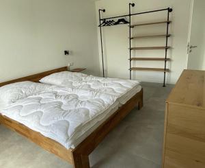 - une chambre avec un lit avec des draps blancs et une échelle dans l'établissement Ferienwohnung Brandung - Haus Seeschwalbe, à Schillig