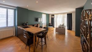 cocina y sala de estar con mesa y sillas en L'art déco, T3 Terrasse, classé meublé de tourisme en Rodez