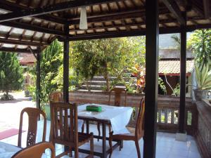 a table and chairs on a porch with a table and chairsktop at Puri Agung Inn in Sidemen