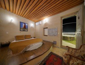 um quarto com uma cama e um tecto em madeira em Karlık Cave Suite Cappadocia em Üçhisar