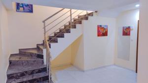a staircase in a room with paintings on the wall at Abuja Modern Apartments in Abuja