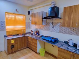 a kitchen with wooden cabinets and a counter top at Abuja Modern Apartments in Abuja
