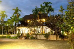 une maison avec des palmiers devant elle dans l'établissement Sclass Villa & Swimming pool , 10 min from airport, à Chiang Mai