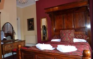 a bedroom with a large wooden bed with two pillows at The Red Lion in Llangadog