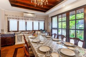 a dining room with a long table with chairs at Sclass Villa & Swimming pool , 10 min from airport in Chiang Mai