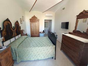 1 dormitorio con 1 cama, vestidor y TV en Locanda della Rocca di Camagna, en Camagna Monferrato