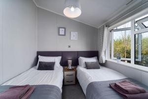 twee eenpersoonsbedden in een kamer met een raam bij Number Four - Piran View in Padstow