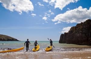a group of people standing in the water with kayaks at urchin Loft in Ardmore