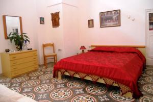 パトゥにあるLa casa di Angelaのベッドルーム1室(赤いベッド1台、ドレッサー付)