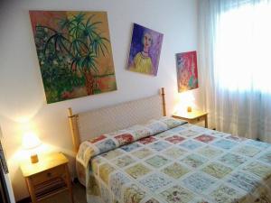 a bedroom with a bed and paintings on the wall at B&B Cà d'Artisti in Caorle