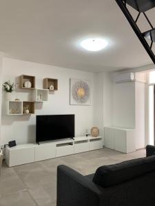 ein weißes Wohnzimmer mit einem Flachbild-TV in der Unterkunft Casa vacanze Elegance in Catania
