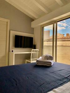 sypialnia z łóżkiem z telewizorem i łóżkiem w obiekcie Casa vacanze Elegance w Katanii