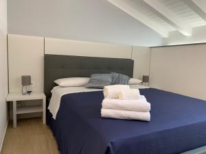 a bedroom with a blue bed with towels on it at Casa vacanze Elegance in Catania
