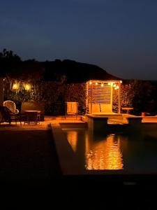 a view of a patio at night with a body of water at Mas Coeur de Provence Calme Luxe Grand Parc in Pernes-les-Fontaines