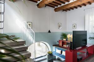 uma sala de estar com uma escada e uma televisão em Laqua Vineyard em Terricciola