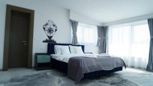 una camera con un grande letto in una stanza con finestre di Eco Friendly a Deva