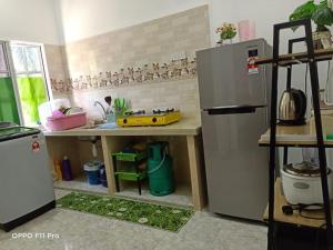 a kitchen with a stainless steel refrigerator and a counter at Safiyya Homestay in Pantai Cenang