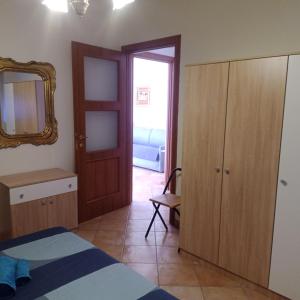 1 dormitorio con cama, espejo y puerta en Appartamento BLU - Colori del Lago D'Orta - NUOVA STRUTTURA A OMEGNA en Omegna