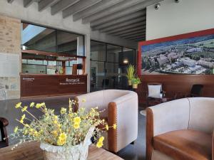 - un salon avec deux chaises et une table fleurie dans l'établissement Hostatgeria de Poblet, à Poblet