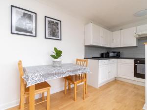 a kitchen with white cabinets and a table with chairs at Pass the Keys One bed flat with stunning views and free parking in Bath
