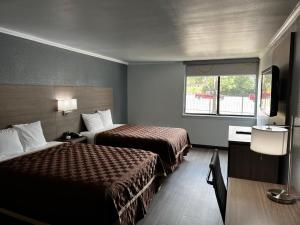 a hotel room with two beds and a window at Super 8 by Wyndham Fort Worth Entertainment District in Fort Worth