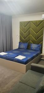 a large bed with blue sheets and blue pillows at Casa Achim in Baia Mare