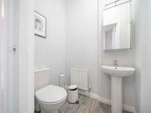 a white bathroom with a toilet and a sink at Pass the Keys Bright Airy 1BR Apt Next to Cafes Queens Uni in Belfast