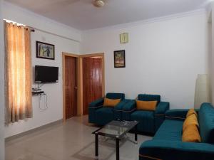 un soggiorno con divano blu e TV di R.H.S VILLA a Varanasi