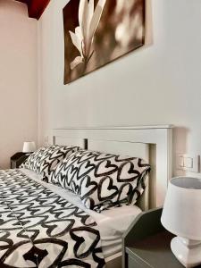 1 dormitorio con 1 cama con edredón blanco y negro en Da Alina, en Marostica