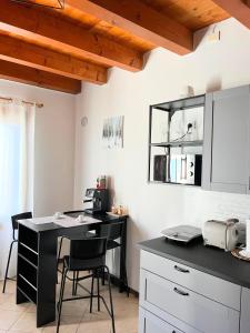 cocina con encimera negra y escritorio con sillas en Da Alina, en Marostica