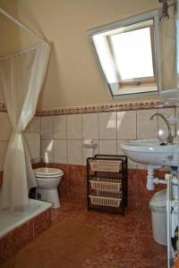a bathroom with a sink toilet and a window at Margaret Apartman in Egerszalók