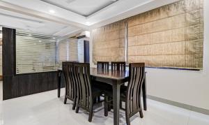a dining room with a black table and chairs at Treebo Elite Premium Homes in Bangalore