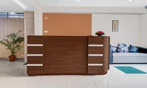 a wooden cabinet in a living room with a couch at Treebo Trend Elite Premium Homes in Bangalore