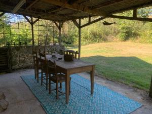 a wooden table and chairs under a pavilion at Maison L’Atelier in Thollet