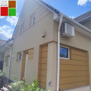a house with a garage and a air conditioner at Color Apartmanok Eger in Eger