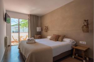 塔马留Hostal Es Niu de Tamariu的一间带大床的卧室和一个阳台