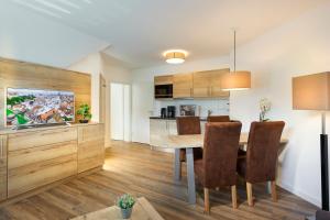 AVITAL Resort في وينتربرغ: مطبخ وغرفة طعام مع طاولة وكراسي خشبية