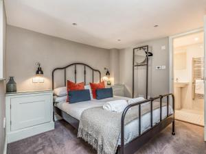 um quarto com uma cama com almofadas laranja e azul em Pass the Keys Modern Central Chichester Studio wParking Wi-Fi em Chichester