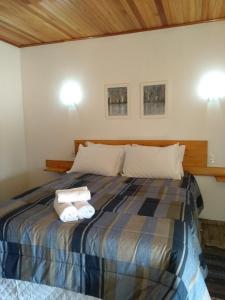a bedroom with a bed with two towels on it at POUSADA AURORA in Mundo Novo