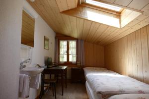 a bathroom with two beds and a sink in a room at Landgasthof Tännler in Innertkirchen