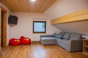 sala de estar con sofá y 2 bolsas rojas en Farmhouse Soklic, en Bohinj