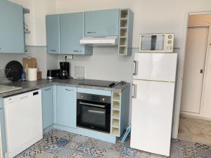 アルカションにあるAppartement Arcachon, 3 pièces, 6 personnes - FR-1-374-74のキッチン(青いキャビネット、白い冷蔵庫付)