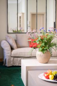 een woonkamer met een tafel met een vaas met bloemen bij Central and Roomy near the Station and Duomo - HomeUnity in Florence