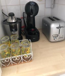 - un comptoir de cuisine avec une cafetière et des verres de fleurs dans l'établissement Mon Appart avec Terrasse et Piscine, à Roquebrune-Cap-Martin